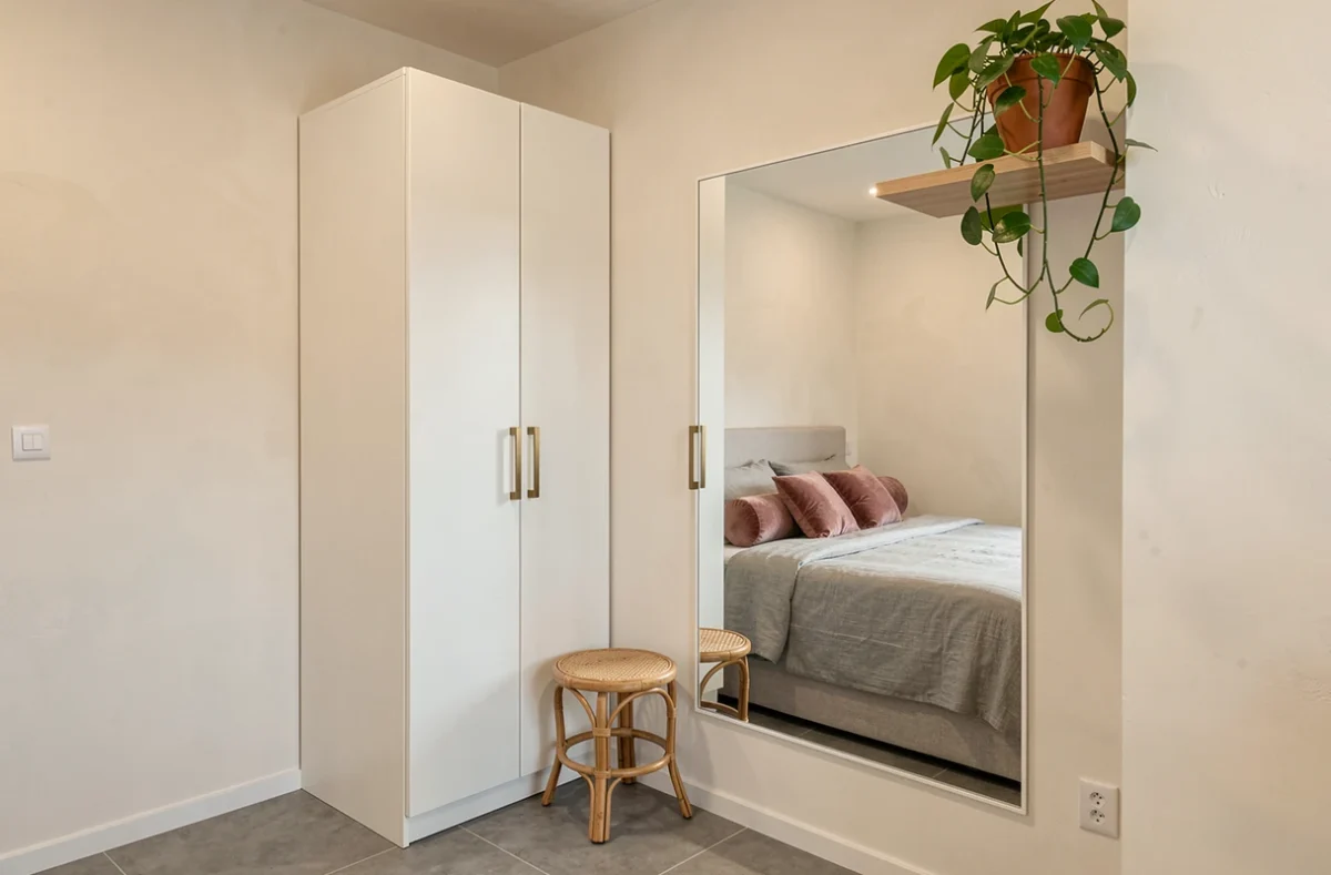Coin dressing intégré dans une suite parentale 15m2, portes laquées blanc mat et poignées laiton brossé, décoration tendance 2026